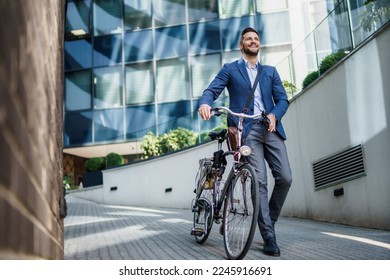 Happy middle age caucasian stylish businessman going to work by bike 