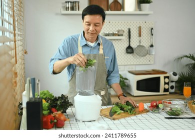 Happy middle age man making vegetable smoothies with blender in kitchen. Healthy lifestyle concept - Powered by Shutterstock