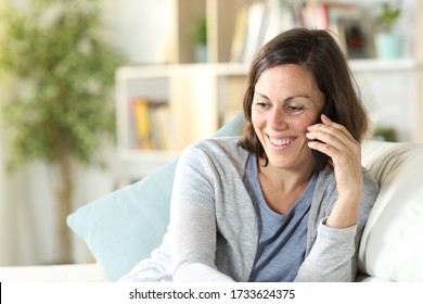 Happy Middle Age Woman Calling On Smart Phone Sitting On The Couch At Home