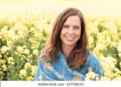 Happy Middle Age Woman In Yellow Field In Nature