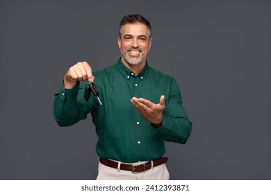 Happy middle aged business man seller, smiling older professional salesman car dealer looking at camera holding keys advertising car sale, leasing rental service standing isolated on gray background. - Powered by Shutterstock