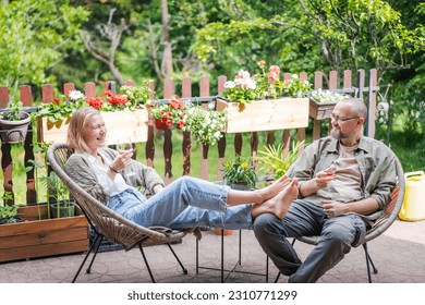 Happy middle aged caucasian couple enjoying a summer day drinking wine on the terrace of a country house. Summer lifestyle  - Powered by Shutterstock