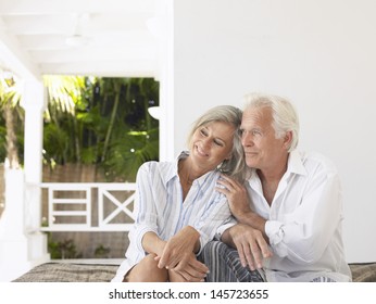 Happy middle aged couple sitting on verandah - Powered by Shutterstock