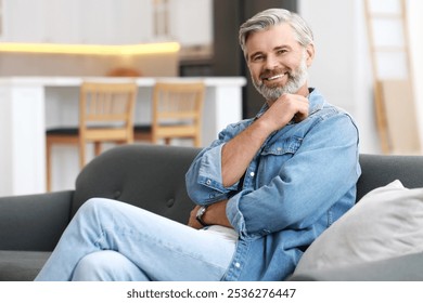 Happy middle aged man on sofa indoors - Powered by Shutterstock