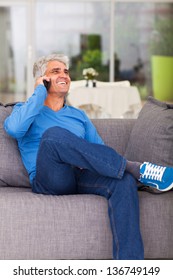 Happy Middle Aged Man Talking On Cell Phone At Home