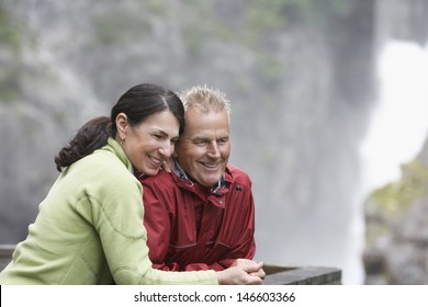 Happy Middle Aged Man And Woman Looking At View Against Blurred Background