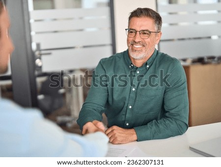 Happy middle aged mature business man hr manager, lawyer and client shake hands at office meeting interview making successful partnership agreement, financial bank deal with handshake. Onboarding.