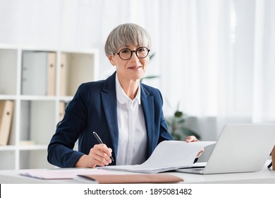 happy middle aged team leader signing document on desk - Shutterstock ID 1895081482
