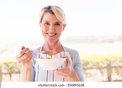 Happy Middle Aged Woman Eating Salad At Home