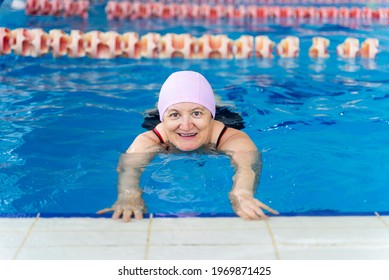 Happy Middle Aged Woman Learning To Swim In A Swimming Pool