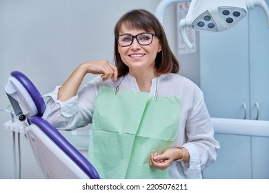 Happy Middle Aged Woman Patient Looking At Camera Sitting In Dental Chair