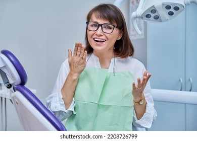 Happy Middle Aged Woman Patient Looking At Camera Sitting In Dental Chair