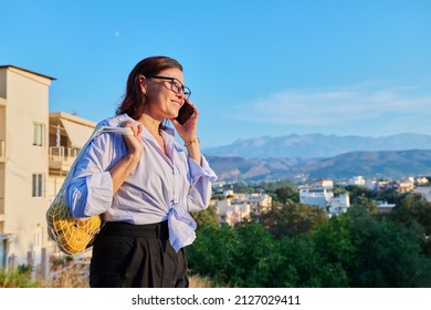 Happy Middle Aged Woman Talking On Mobile Phone Outdoor.