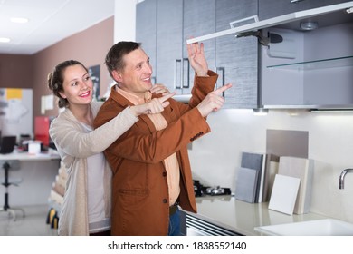 Happy Middle Class Family Selecting Modern Kitchen Furniture