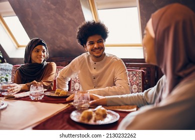 Happy Middle Easter Man And His Family Enjoying In Desert And Talking At Dining Table.