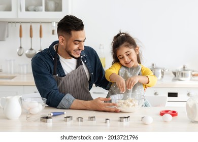 Happy Middle Eastern Father And Daughter Preparing Dough For Cookies Together, Cheerful Arab Dad And Female Child Having Fun While Baking In Kitchen, Enjoying Cooking Homemade Food, Free Space