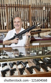 Happy Middle-aged Man With Rifle In Gun Store