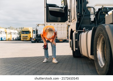 Happy Middle-aged Woman Checking Tires And Gas Tank Of Semi-truck Vehicle 