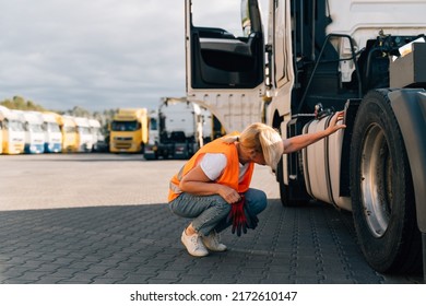 Happy Middle-aged Woman Checking Tires And Gas Tank Of Semi-truck Vehicle 