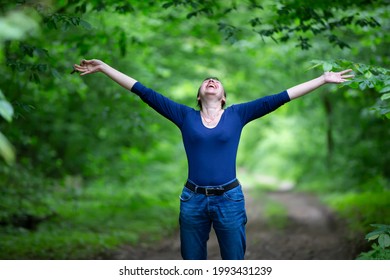 Happy Middle-aged Woman Spread Her Arms In The Forest.