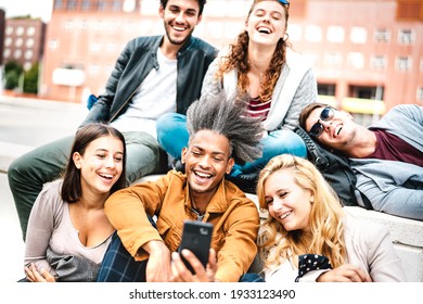 Happy milenial people having fun sharing photo on mobile phone after lockdown reopening - Joyful concept about guys and girls spending time together outdoor at university college - Warm bright filter - Powered by Shutterstock