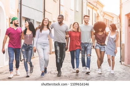 Happy milennials friends walking in old town city centre - Young people having fun together - Youth lifestyle and friendship concept - Focus on center guys  - Powered by Shutterstock