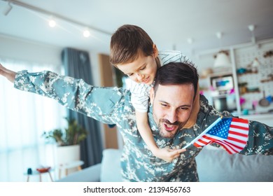 Happy military man with his son at home. An emotional military father, dressed in camouflage, holds his young son in arms in greeting after returning home from a tour of duty overseas. - Powered by Shutterstock