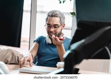 Happy Millenial Business Man Using Mobile Phone While Working Inside Coworking Office - Focus On Face