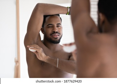 Happy Millennial African American Man Applying Dry Deodorant Stick In Underarm Pit, Preventing Perspiration After Daily Morning Body Cleansing Procedures In Bathroom, Getting Ready For Workday.