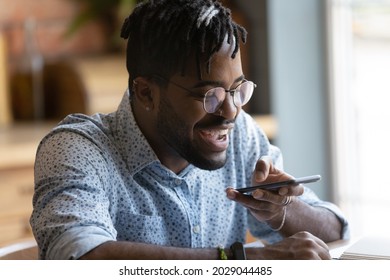 Happy millennial Black hipster guy using voice recognition app on smartphone, recording audio message for chat, messenger, giving virtual voice command, using translation service - Powered by Shutterstock - Get 15% off with code: PIKWIZARD15