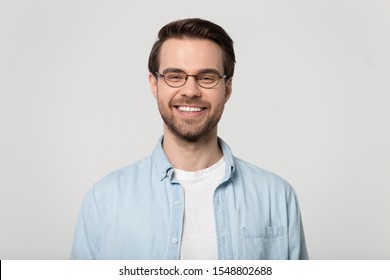 Happy Millennial Caucasian Guy Wear Glasses Isolated On Grey Studio Background Smiling With White Healthy Teeth, Positive Young Man In Casual Clothes Posing Look At Camera Show Good Treatment Result