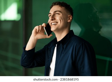 Happy millennial caucasian man enjoy communication, calling by smartphone, got good news, look at free space, on green wall background, close up. Work, success business, study conversation - Powered by Shutterstock