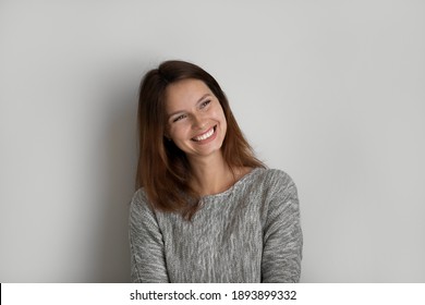 Happy millennial Caucasian woman isolated on grey studio background look in distance planning or dreaming. Happy young red-haired female feel overjoyed inspired daydream or visualize at home. - Shutterstock ID 1893899332