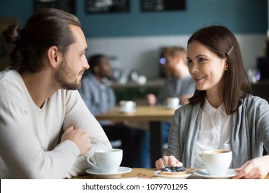 Happy Millennial Couple In Love Talking Sitting At Coffee House Table Together, Smiling Young Attractive Man And Woman Chatting And Flirting Enjoying Pleasant Conversation, Date In Cafe Concept