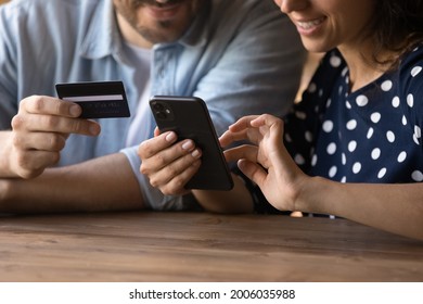 Happy Millennial Couple Shopping Online, Making Payment For Purchase, Using Banking App Or Service On Mobile Phone, Virtual Wallet, Credit Card, Booking Hotel Room, Paying For Travel Ticket. Close Up