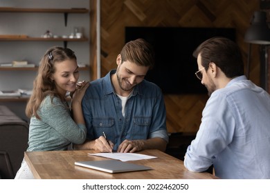 Happy millennial couple signing property purchase contract, insurance agreement, filling bank application for mortgage, buying house, loan. Young married man and woman meeting with legal expert - Shutterstock ID 2022462050