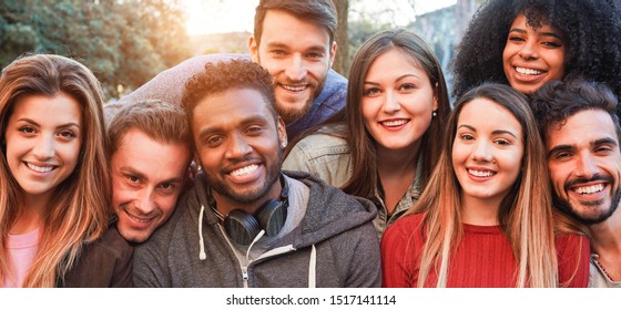 Happy millennial friends from diverse cultures and races having fun posing in front of smartphone camera - Youth and friendship concept - Young multiracial people smiling - Main focus on african man