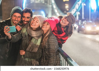 Happy Millennial Friends Taking Slow Motion Videos On City Bridge At Night Time - Young People Having Fun With New Trends Technology - Travel And Friendship Concept - Focus On Two Center Girls Faces