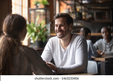 Happy millennial man meeting in cafe with young woman enjoying coffee and talk together, loving young couple have fun laughing hanging out in restaurant, friends or colleague have break outside - Powered by Shutterstock