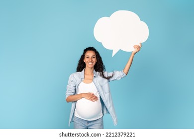 Happy Millennial Pregnant Arab Woman With Belly Holding Abstract Cloud Buble With Copy Space, Isolated On Blue Background, Studio. Great Ad And Offer, Idea, Love, Motherhood And Expectation Baby