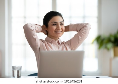 Happy Millennial Professional Satisfied With Good Job Result. Relaxed Indian Business Woman Enjoying Work Break At Laptop, Thinking Over Successful Project, Celebrating Achievement. Success Concept