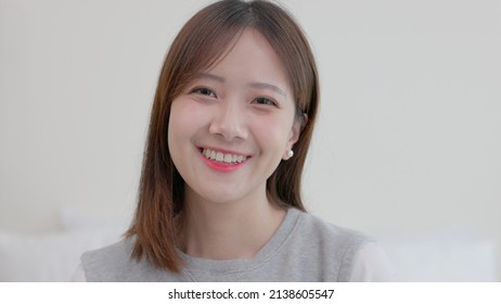 Happy Millennial Thai Ethnicity Lady Student Professional Close Up Front Portrait, Beautiful Smiling Confident Young Thai Ethnic Woman Cute Face Looking At Camera Posing Alone At Home In Home,
