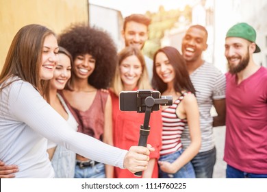 Happy Millennials Friends Making Video Feed With Smartphone Outdoor - Young People Having Fun With New Technology Trends - Youth Lifestyle And Social Media Concept - Focus On Phone Gimbal