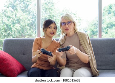 Happy mix skin family living together, asian daughter and her adopted caucasian mother play console games in the living room. - Powered by Shutterstock