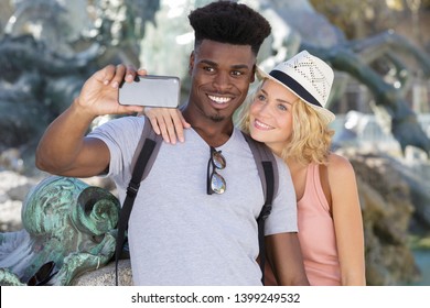 happy mixed couple taking a selfie - Powered by Shutterstock