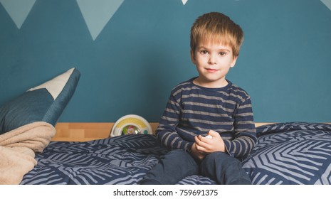 Happy Mixed Race Boy Sitting On Bed