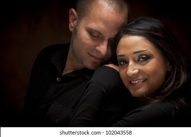 Happy Mixed Race Couple Flirting With Each Other Portrait Against A Black Background.