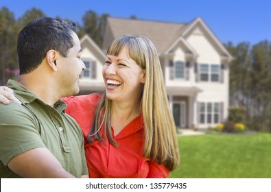 Happy Mixed Race Couple In Front Of Beautiful House.