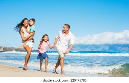 Happy Mixed Race Family Of Four Playing On The Beach