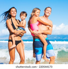 Happy Mixed Race Family Of Four On Tropical Sunny Beach